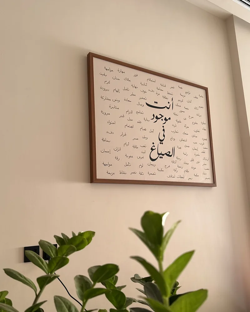 لوحة «أنت موجود في الصياغ» مؤطّرة ومعلّقة على جدار المقهى